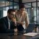 Business professionals reviewing information on a laptop in a modern office