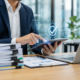 Business professional using a tablet with a digital checkmark interface in a modern office