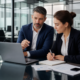 Business professionals reviewing supplier risk assessment documents on a laptop in a meeting room